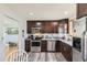 Well lit kitchen with stainless appliances, dark wood cabinets, and vinyl flooring at 15645 E Floyd Ave, Aurora, CO 80013