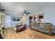 A comfy living room with hardwood floors, gray walls, a ceiling fan, and views to the kitchen at 15645 E Floyd Ave, Aurora, CO 80013