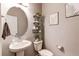 Charming powder room with pedestal sink, decorative shelves, and stylish decor at 5152 Bittercress Rd, Brighton, CO 80640