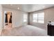 This spacious carpeted bedroom includes two windows and a door that opens to another room at 5152 Bittercress Rd, Brighton, CO 80640