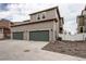 Two-story gray home featuring a two-car garage with a shared driveway and white fence at 5152 Bittercress Rd, Brighton, CO 80640