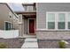 Two-story home featuring a covered front porch with brick accents and a red front door at 5152 Bittercress Rd, Brighton, CO 80640