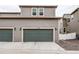 Exterior view of a home with a two-car garage with a concrete driveway and landscaping at 5152 Bittercress Rd, Brighton, CO 80640