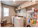 This laundry room includes both a washer and dryer, storage shelves, and wood-look floors at 5152 Bittercress Rd, Brighton, CO 80640