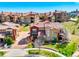 Stunning aerial view of homes with red roofs, lush green lawns, and meticulously landscaped yards in a planned community at 9588 Firenze Way, Highlands Ranch, CO 80126