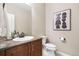 Stylish powder room featuring a vanity, sink, framed mirror and modern decor at 9588 Firenze Way, Highlands Ranch, CO 80126