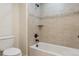 Bathroom featuring a tub and shower with tile surround and a newer toilet at 9588 Firenze Way, Highlands Ranch, CO 80126