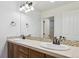 Bathroom featuring a vanity with double sinks, a large mirror, and updated lighting at 9588 Firenze Way, Highlands Ranch, CO 80126