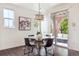 Bright dining area features a modern chandelier, glass table, and access to the outdoor patio at 9588 Firenze Way, Highlands Ranch, CO 80126