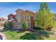Elegant home boasting a stone facade, large windows, manicured lawn, and mature trees, offering curb appeal at 9588 Firenze Way, Highlands Ranch, CO 80126