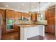 Modern kitchen with stainless appliances, granite counters, custom cabinets, an island and beautiful pendant lighting at 9588 Firenze Way, Highlands Ranch, CO 80126