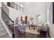 Bright living room with soaring ceilings, dark wood floors, large windows, and elegant staircase at 9588 Firenze Way, Highlands Ranch, CO 80126