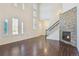 Inviting living room with soaring ceilings, hardwood floors, fireplace, and large windows for natural light at 9588 Firenze Way, Highlands Ranch, CO 80126