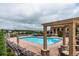 Community pool surrounded by lounge chairs and a covered patio area for residents to enjoy on a cloudy day at 9588 Firenze Way, Highlands Ranch, CO 80126