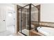 Close-up of the shower with a glass enclosure, bench, and decorative tile work at 9588 Firenze Way, Highlands Ranch, CO 80126