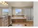 Spacious bathroom featuring double sinks, a soaking tub, stand-alone shower, and large windows at 22 Apache Plume St, Brighton, CO 80601