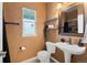 Cozy half bathroom featuring a toilet and sink with decorative mirror at 22 Apache Plume St, Brighton, CO 80601