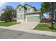 Two story home with a green exterior, 2 car garage and a concrete driveway at 22 Apache Plume St, Brighton, CO 80601