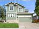 Charming two-story home featuring an attached garage and well-manicured lawn at 22 Apache Plume St, Brighton, CO 80601