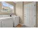 Well-lit laundry room with washer, dryer, and access to exterior at 22 Apache Plume St, Brighton, CO 80601