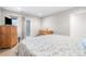 Cozy bedroom with a light floral comforter, wooden dressers, and a door to the outside at 1353 Quaker St, Golden, CO 80401