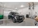 Well-lit garage featuring a dark SUV, overhead storage racks for bicycles, and ample space at 1353 Quaker St, Golden, CO 80401
