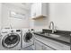 Well-equipped laundry room with front-load washer and dryer and modern sink at 1353 Quaker St, Golden, CO 80401