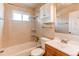 Bathroom with tile surround tub, storage cabinet, and single sink vanity at 9150 Lilly Ct, Thornton, CO 80229