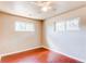 Neutral bedroom with wood floors and two windows letting in natural light at 9150 Lilly Ct, Thornton, CO 80229