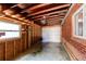 Garage featuring exposed rafters and brick wall, with a large garage door opening at 9150 Lilly Ct, Thornton, CO 80229