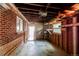 An open garage showcasing exposed rafter beams, brick and wood wall, and an access door at 9150 Lilly Ct, Thornton, CO 80229