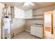 Laundry room with utility sink, cabinets, shelving, and tile flooring at 9150 Lilly Ct, Thornton, CO 80229