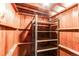 Storage room with exposed wooden beams featuring built-in shelving and metal storage rack at 9150 Lilly Ct, Thornton, CO 80229