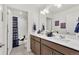 Bathroom with a double vanity, modern fixtures, a separate toilet, and a shower featuring navy blue curtains at 15833 Little Bluestem Rd, Monument, CO 80132