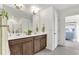 Bright bathroom with a double sink vanity, modern fixtures, decor, and a view into an adjoining bedroom at 15833 Little Bluestem Rd, Monument, CO 80132