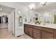 Bathroom featuring a double sink vanity with modern fixtures, decor, and a view into the walk-in closet at 15833 Little Bluestem Rd, Monument, CO 80132