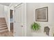 Hallway showcasing a staircase, door, artwork, and decorative plant at 15833 Little Bluestem Rd, Monument, CO 80132