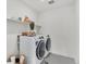 Well-lit laundry room with modern washer and dryer and shelving space at 15833 Little Bluestem Rd, Monument, CO 80132
