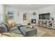 Bright living room with a plush gray sectional, fireplace, and decorative furnishings at 15833 Little Bluestem Rd, Monument, CO 80132