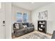 Cozy living room features a comfy grey couch, neutral rug, bookshelf, and natural light, creating a welcoming atmosphere at 15833 Little Bluestem Rd, Monument, CO 80132