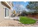 A well-maintained backyard featuring a concrete patio, lush green lawn, and mature trees at 9378 Longstone Dr, Parker, CO 80134