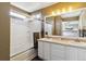 Bathroom features a double sink vanity and bathtub with sliding glass door at 9378 Longstone Dr, Parker, CO 80134