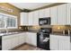 Well-lit kitchen with stainless steel sink, black appliances, and bright white cabinetry at 9378 Longstone Dr, Parker, CO 80134