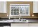 Close up of a clean kitchen sink with a window overlooking the backyard at 9378 Longstone Dr, Parker, CO 80134