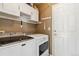 Practical laundry room with modern washer and dryer units, storage cabinets, and convenient access door at 9378 Longstone Dr, Parker, CO 80134