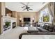 Bright living room with fireplace, plush sectional sofa, and large windows offering natural light at 9378 Longstone Dr, Parker, CO 80134