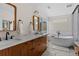 Bright bathroom with freestanding tub and wood vanity with marble countertop at 1845 W 33Rd Ave, Denver, CO 80211