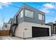 Contemporary two-story home featuring a black garage door, modern architecture, and industrial outdoor staircase at 1845 W 33Rd Ave, Denver, CO 80211