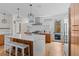 Open kitchen with stainless steel appliances, wood cabinets, large island, and designer lighting at 1845 W 33Rd Ave, Denver, CO 80211