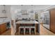 Open kitchen with stainless steel appliances, wood cabinets, large island with seating, and designer lighting at 1845 W 33Rd Ave, Denver, CO 80211